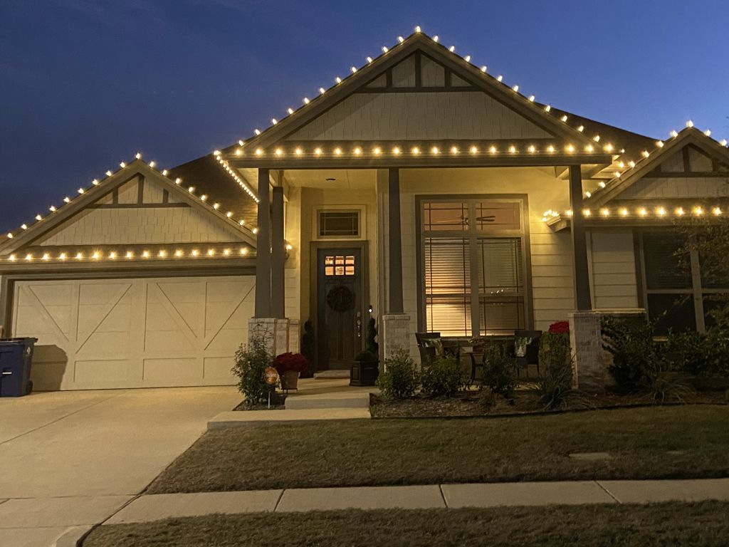 Craftsman home in Burleson, TX outlined in warm white holiday lights